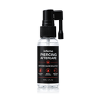A clear plastic bottle of inferno Piercing Aftercare Isotonic Saline Solution with a black spray pump cap, shown on a white background with a subtle reflection.